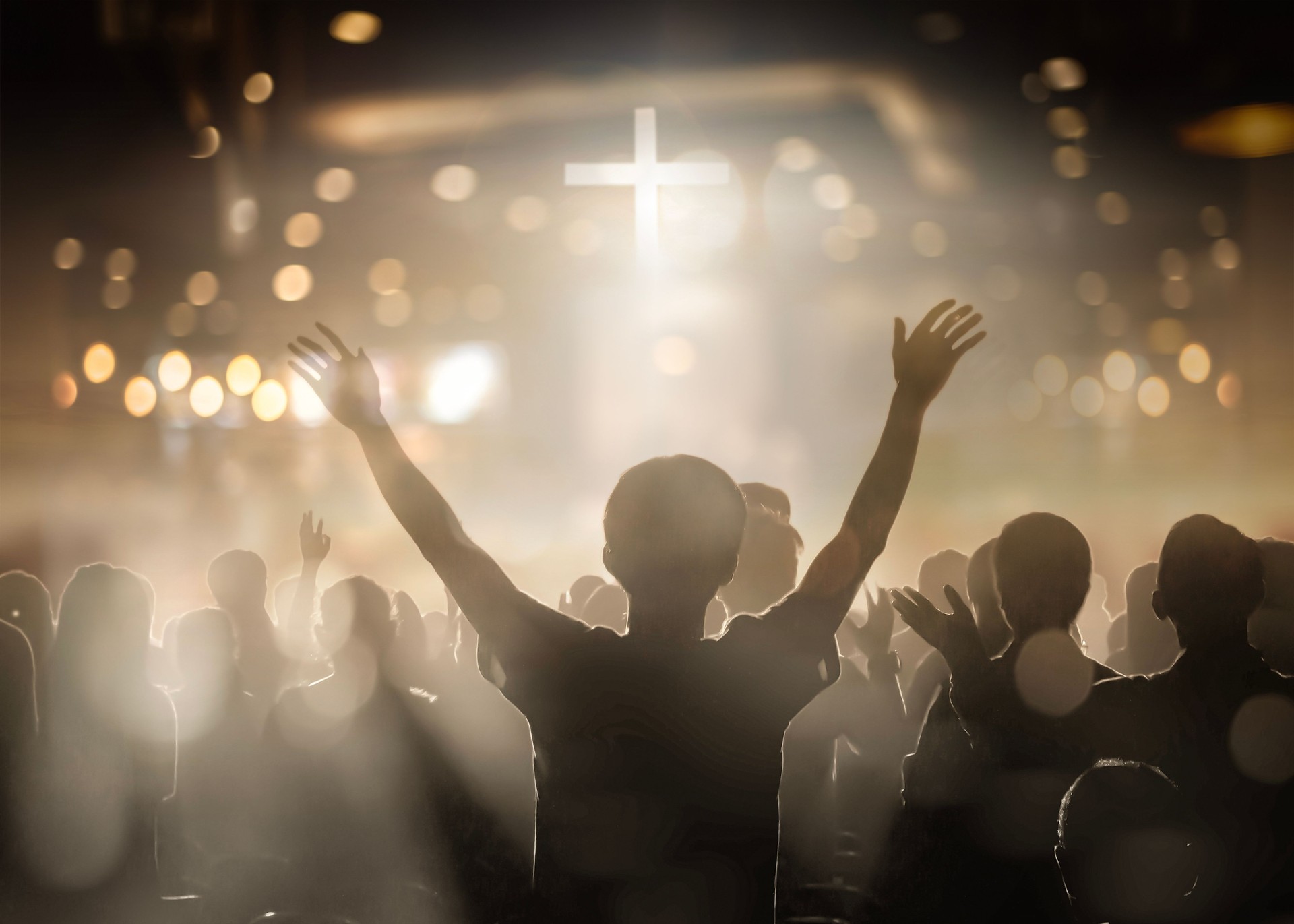Christians raising their hands in praise and worship at a night music concert